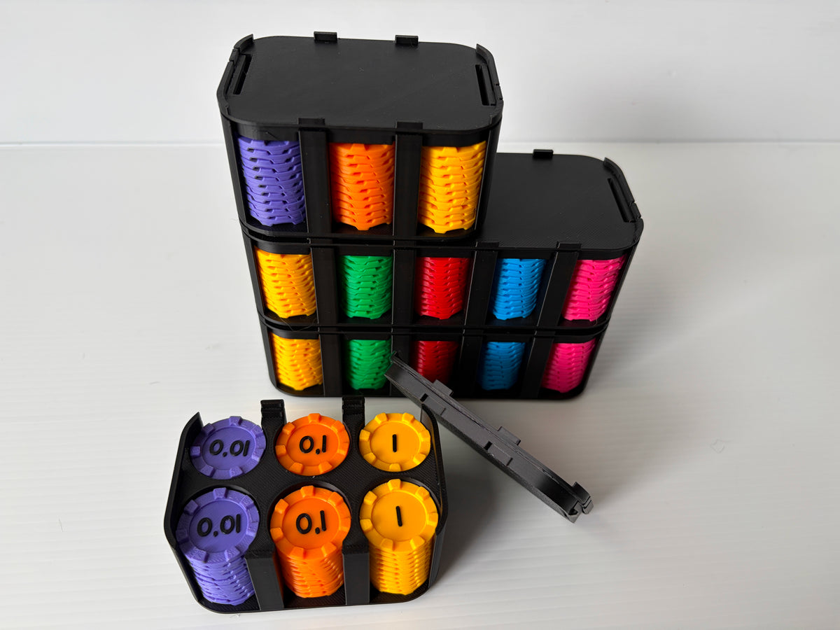 Petit boitier noir ouvert avec des jetons 0,01, 0,1 et 1, devant des boitiers fermés et empilés remplis de jetons colorés
