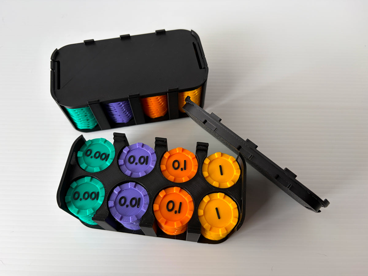 Boitier noir ouvert avec des jetons turquoise (0,001), violets (0,01), orange (0,1) et jaunes (1), devant un boitier fermé