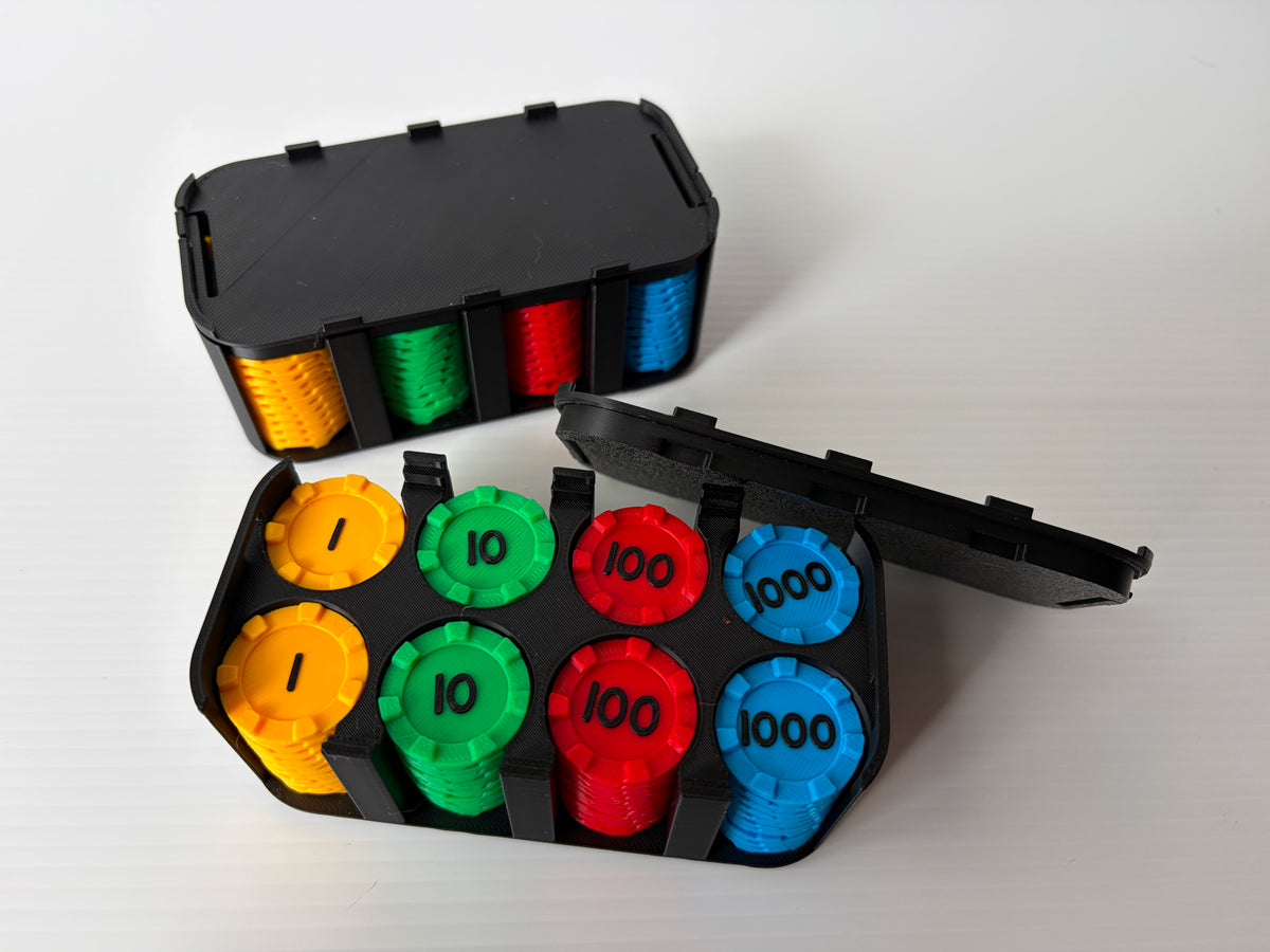 Boitier noir ouvert avec des piles de jetons jaunes (1), verts (10), rouges (100) et bleus (1000), devant un boitier fermé