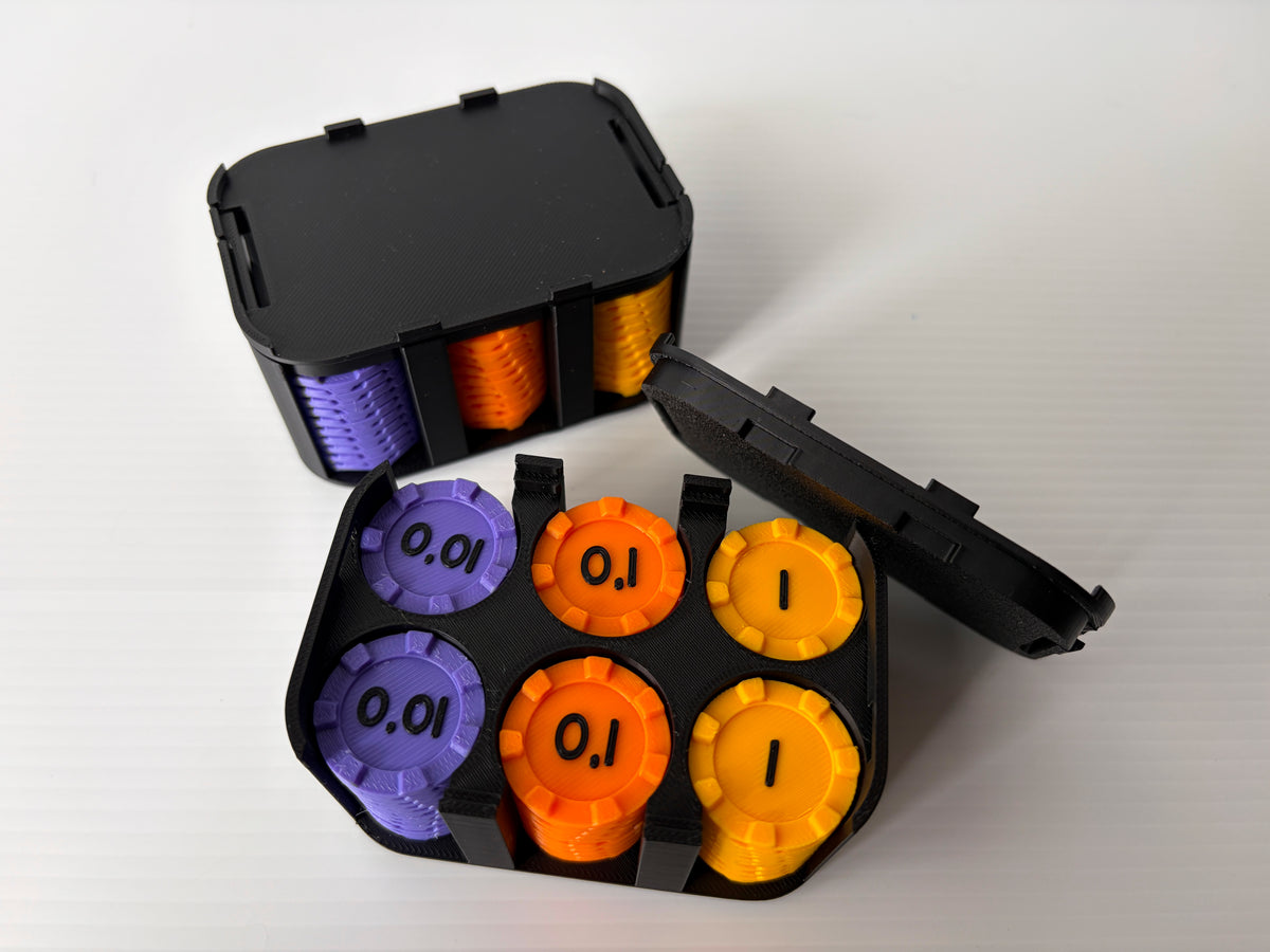 Boitier noir ouvert avec des jetons violets (0,01), orange (0,1) et jaunes (1), devant un boitier fermé