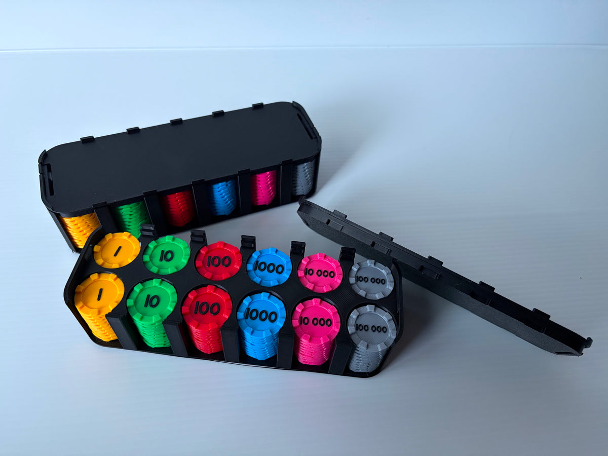 Boitier noir ouvert avec des jetons de 1, 10, 100, 1000, 10 000 et 100 000 en six couleurs, devant un boitier fermé